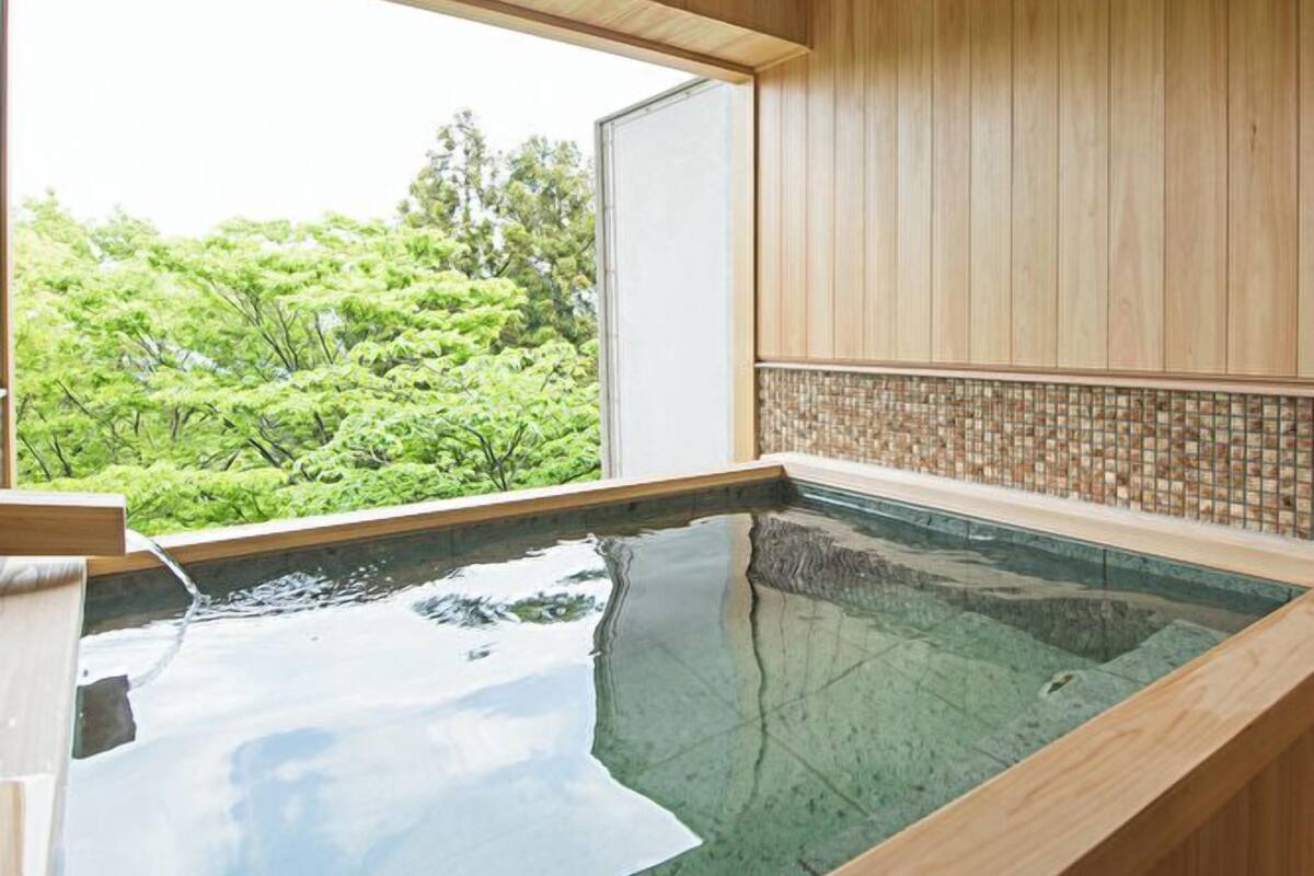 A wooden interior with a large window overlooking a lush garden.