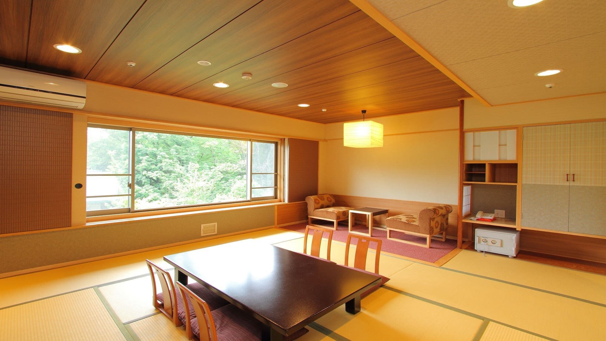 A traditional Japanese room with tatami flooring, a low table, chairs, a sofa, and a cabinet.