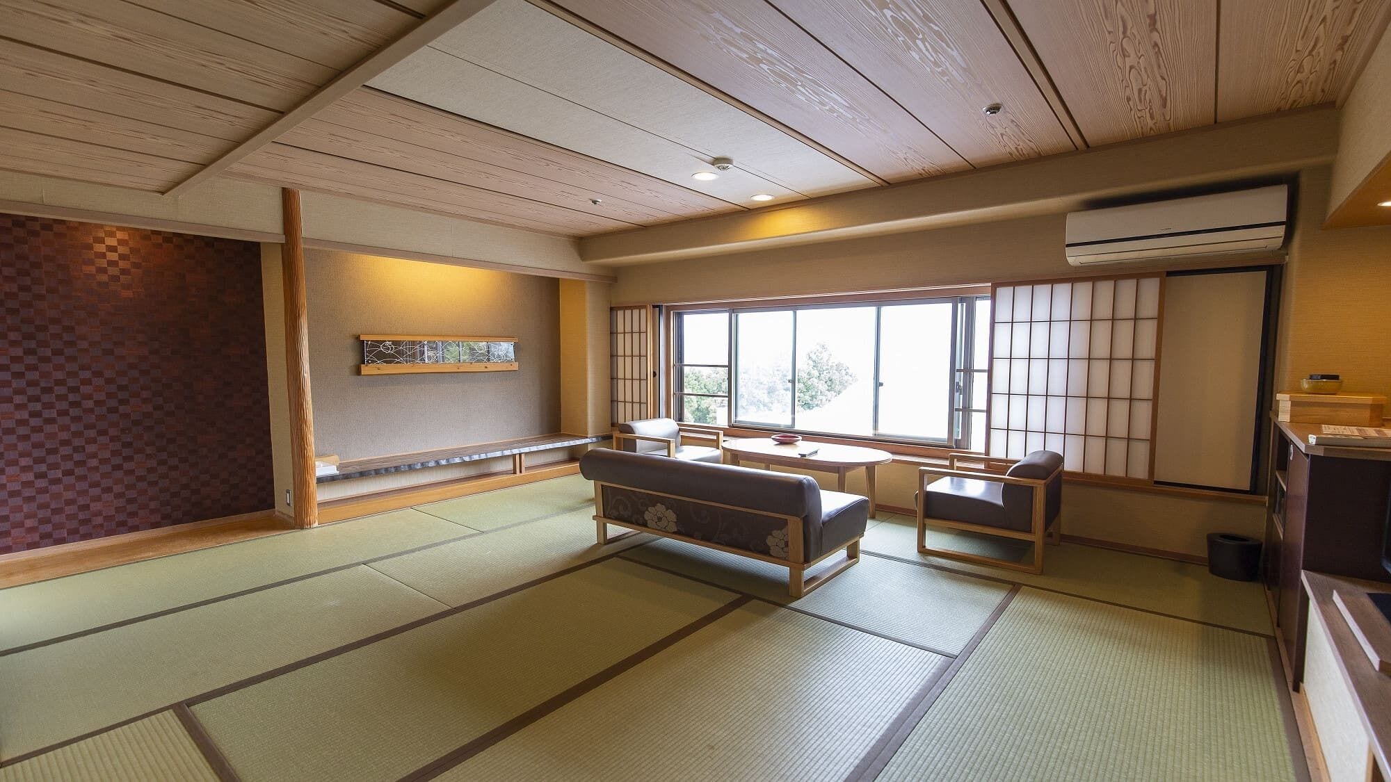 A traditional Japanese room with tatami flooring, a low table with cushions, and sliding doors.