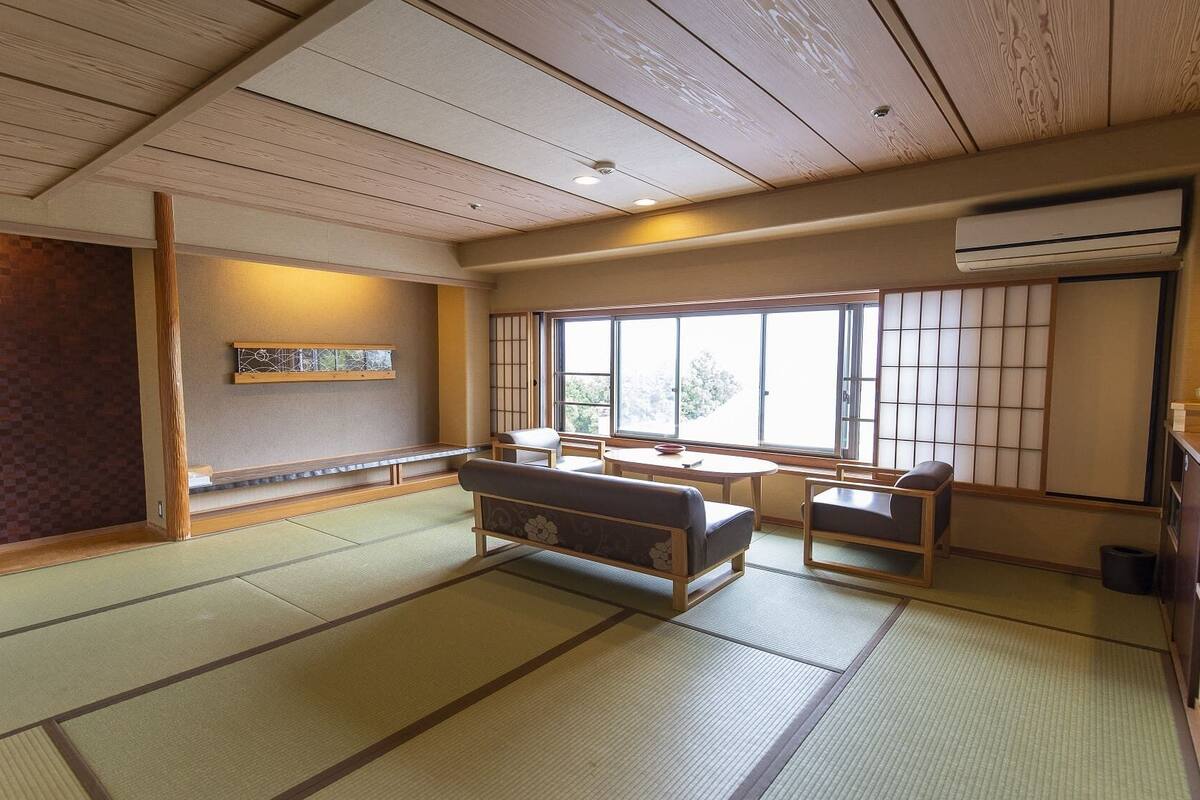 A traditional Japanese room with tatami flooring, a low table with cushions, and sliding doors.