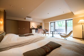 A hotel room with two beds, a kitchenette, a dining area, and a large window with a view of the outdoors. - Hotel Tenbo (Shibukawa)