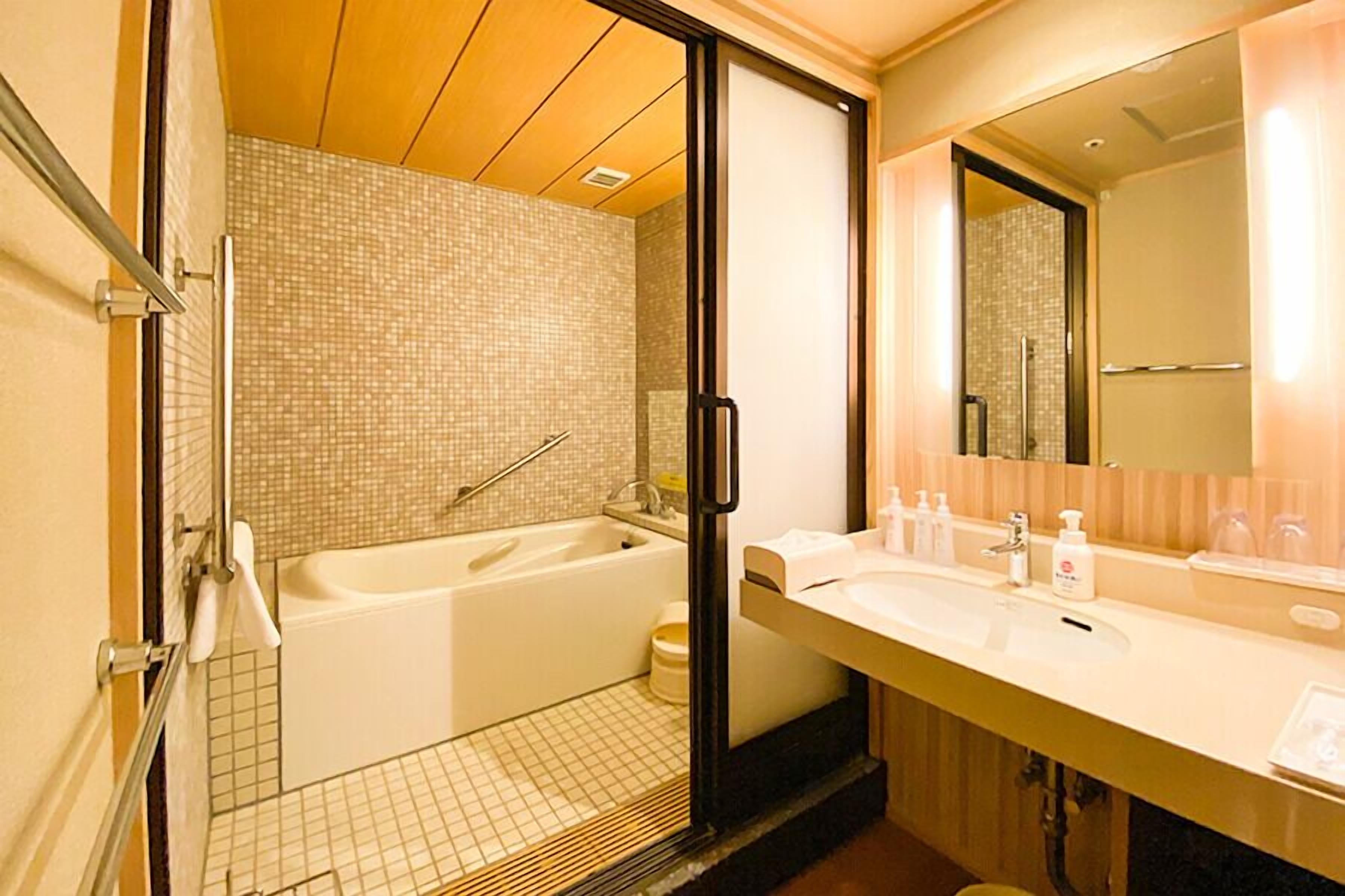 A modern bathroom with a bathtub, a shower, and a vanity with a mirror.