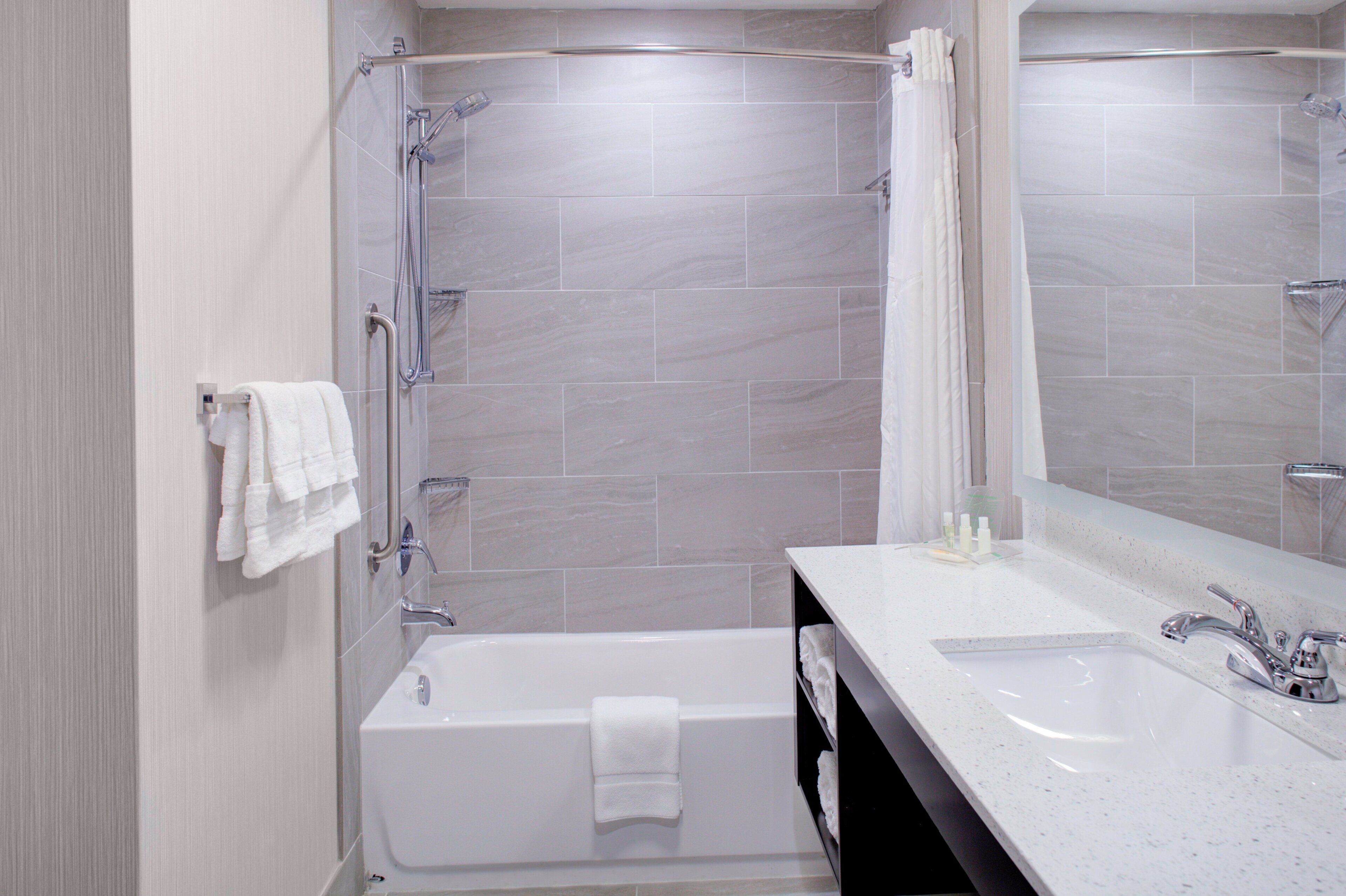 A modern bathroom with a bathtub, a shower, and a sink.
