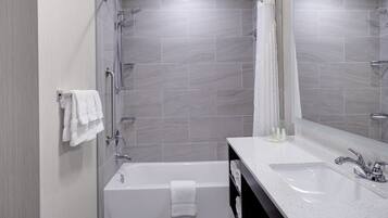 A modern bathroom with a bathtub, a shower, and a sink.