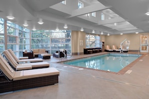A swimming pool area with lounge chairs and a no diving sign.
