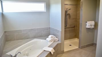 Une salle de bain moderne avec une baignoire, une douche et une fenêtre.