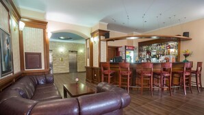 Zona de bar con sofás de cuero y una barra.