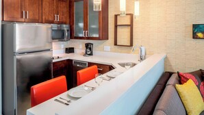 Een moderne keuken met roestvrijstalen apparatuur, houten kasten en een centraal kookeiland met zitplaatsen.