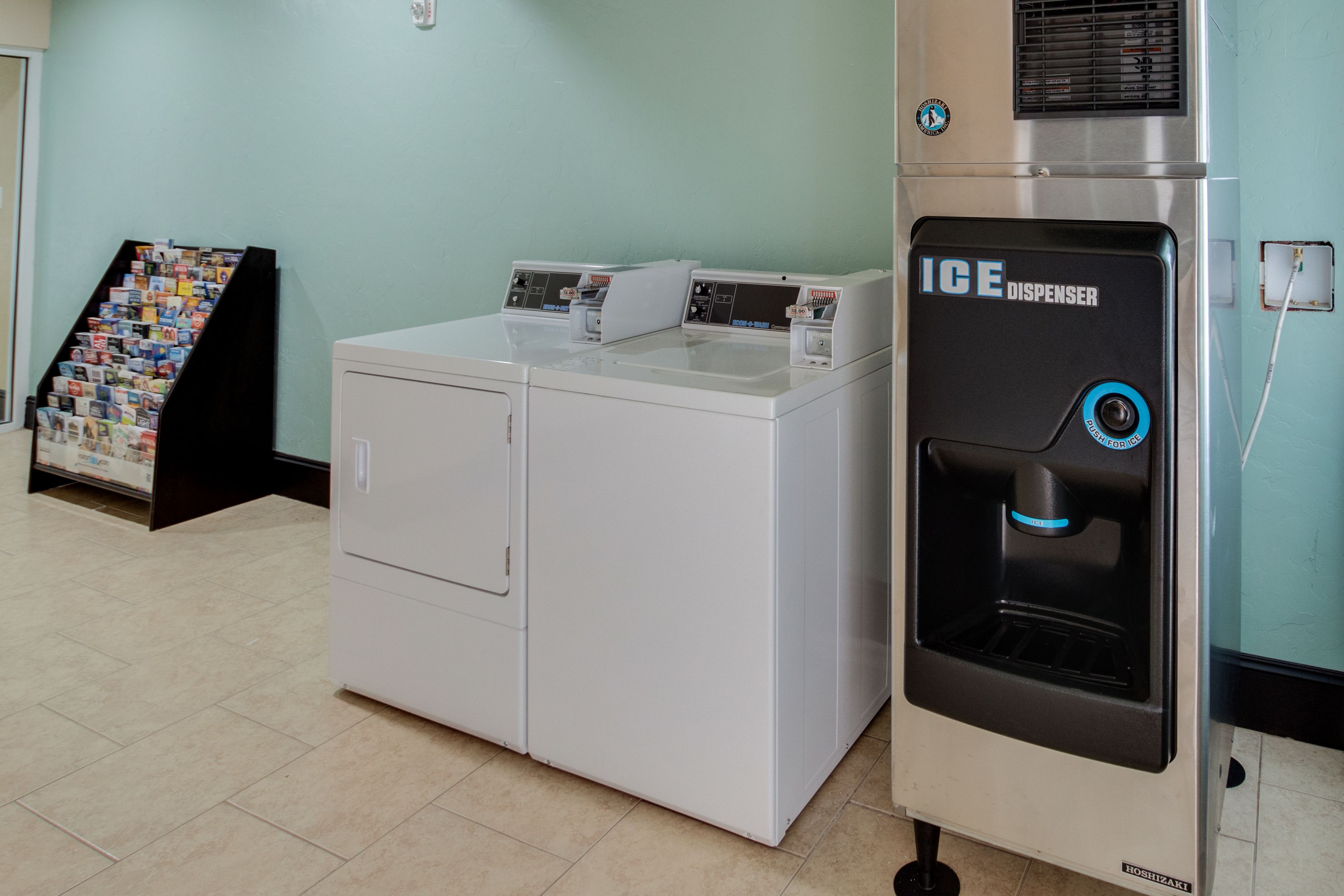 A laundry area with a white washer and dryer, and an ice dispenser.