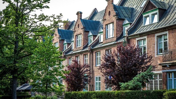 A row of brick townhouses with steeply pitched roofs and dormer windows. - Hotel Logos (Gdansk)