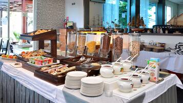 A buffet setup with various food items and utensils.