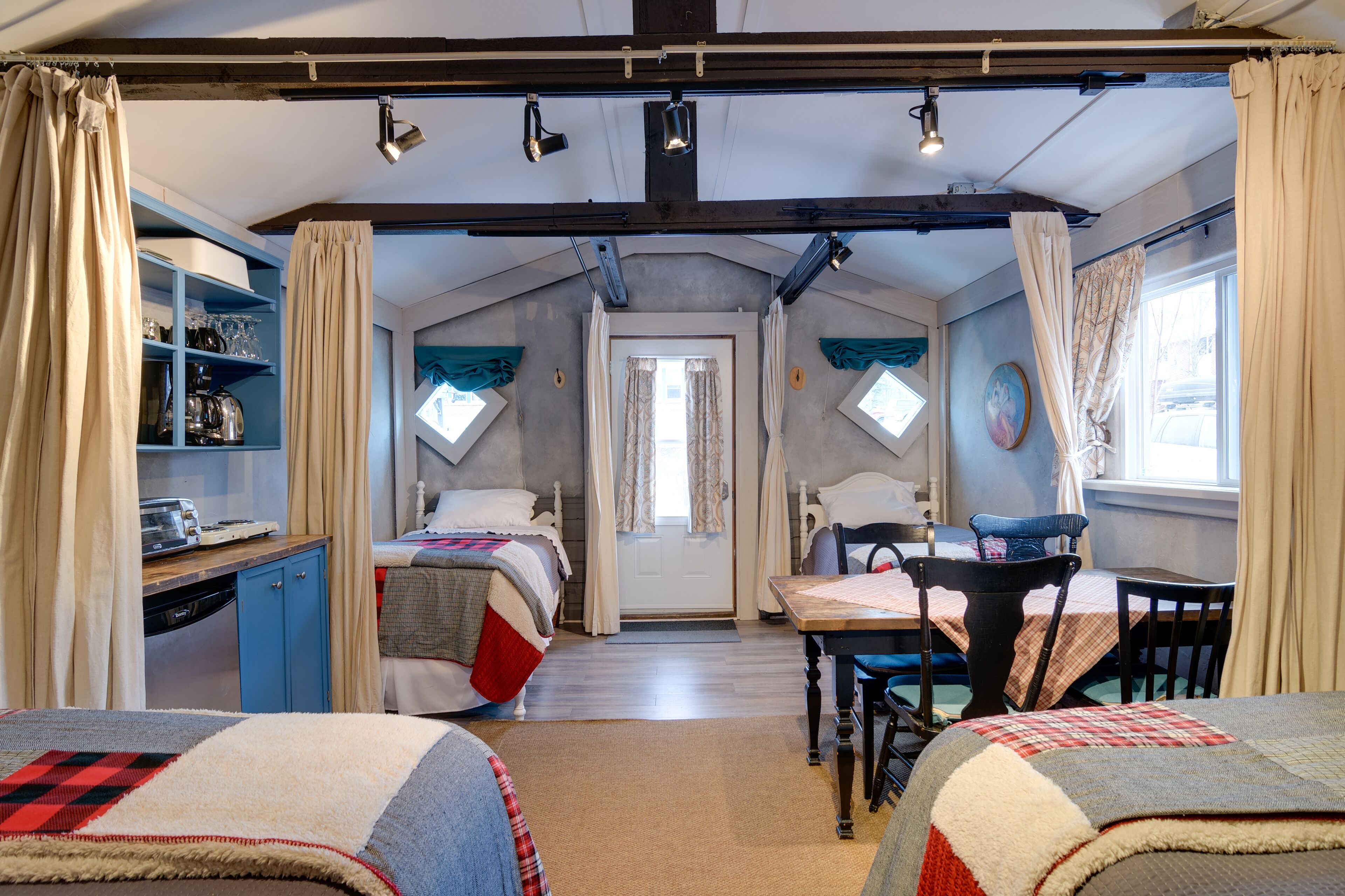 Un dormitorio acogedor con dos camas, un escritorio y una mesa de comedor.