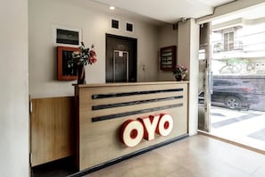 A reception desk with a wooden finish and a large 'OVO' sign.