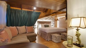 A cozy room with a bed, a sofa, a small table, and a lamp. - Archontariki Boutique Hotel (Ioannina)