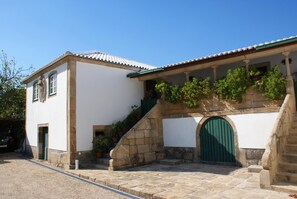 A building with a stone staircase, a green door, and a white facade.