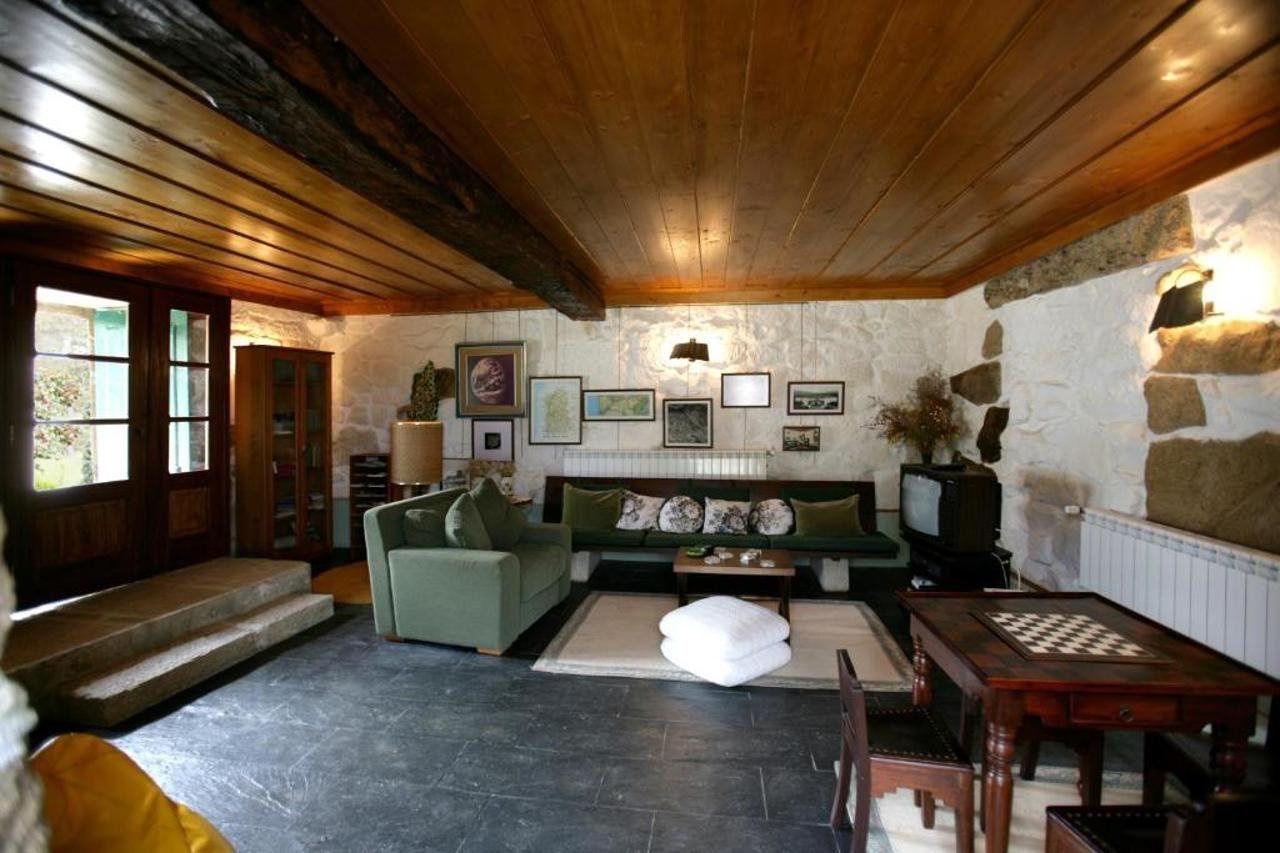 Un salón acogedor con chimenea, sofá verde y una mesa de ajedrez.