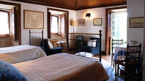 A room with two beds, a desk, and a chair. - Quinta Da Calcada (Melgaço)