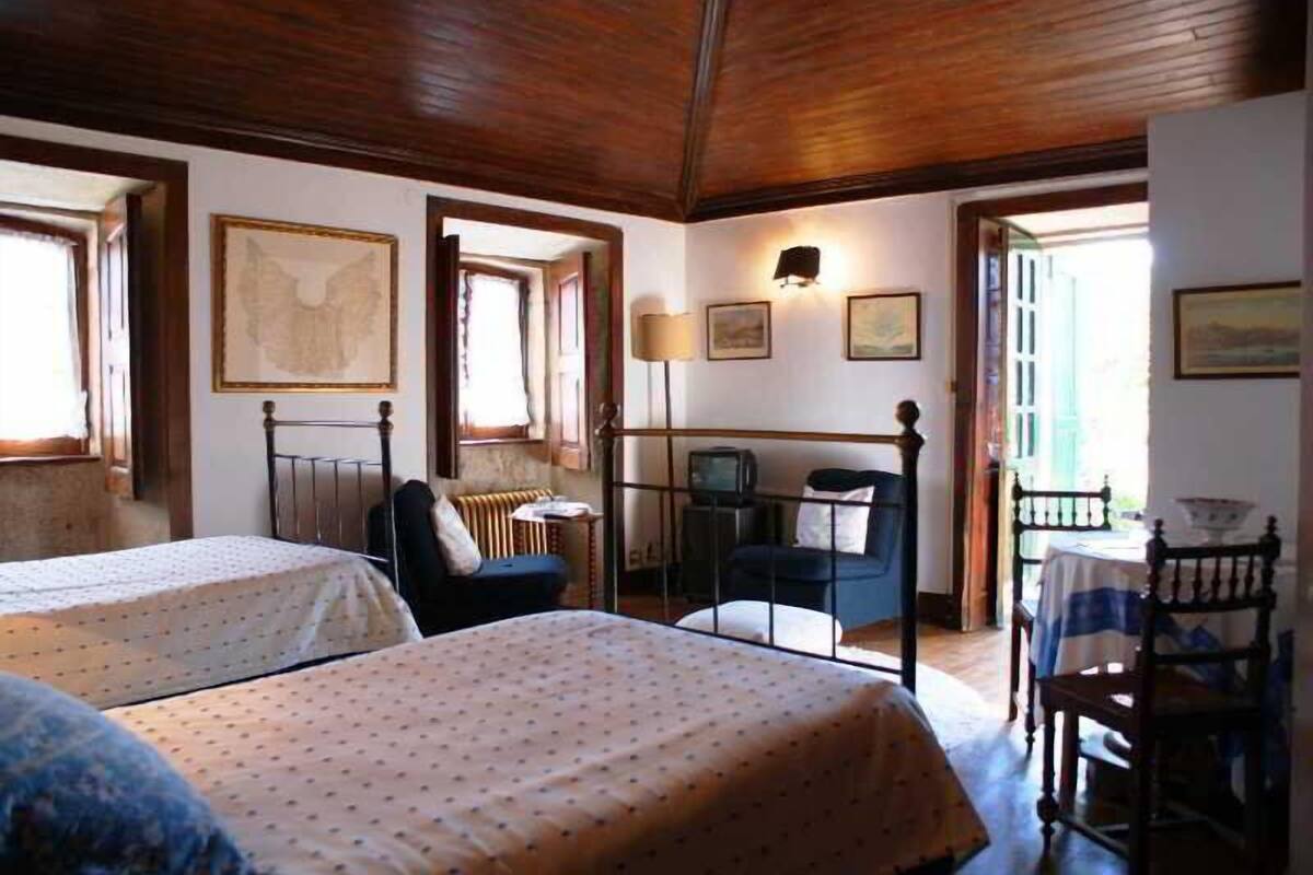 Una habitación con dos camas, un escritorio y una silla.