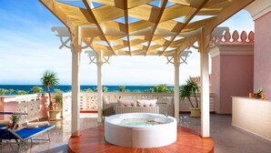 A circular wooden deck with a hot tub, lounge chairs, and a view of the sea. - Pickalbatros Palace Hurghada (Hurghada)