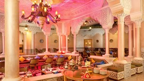 An opulent interior with ornate arches, a central seating area with tables, and a chandelier. - Pickalbatros Palace Hurghada (Hurghada)