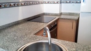 A kitchen with granite countertops, a stainless steel sink, and a dishwasher. - Benicarlo 3000 (Benicarlo)