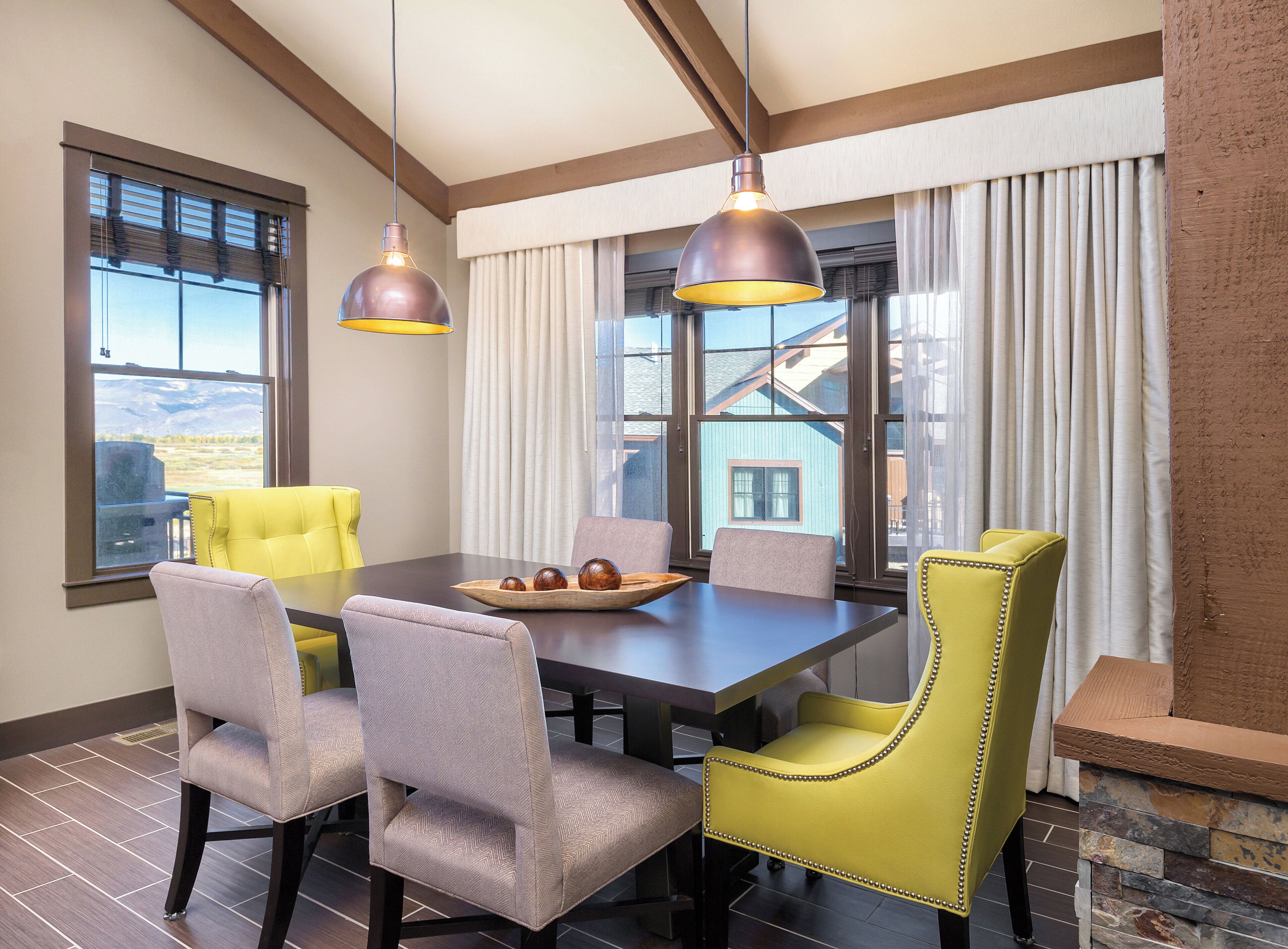 A dining area with a table, chairs, and pendant lights.