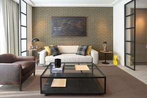Una sala de estar moderna con un sofá de cuero, una mesa de centro de vidrio y un mapa mundial en la pared.