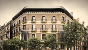 Un edificio de varios pisos con fachada curva, varios balcones y ventanas amplias.