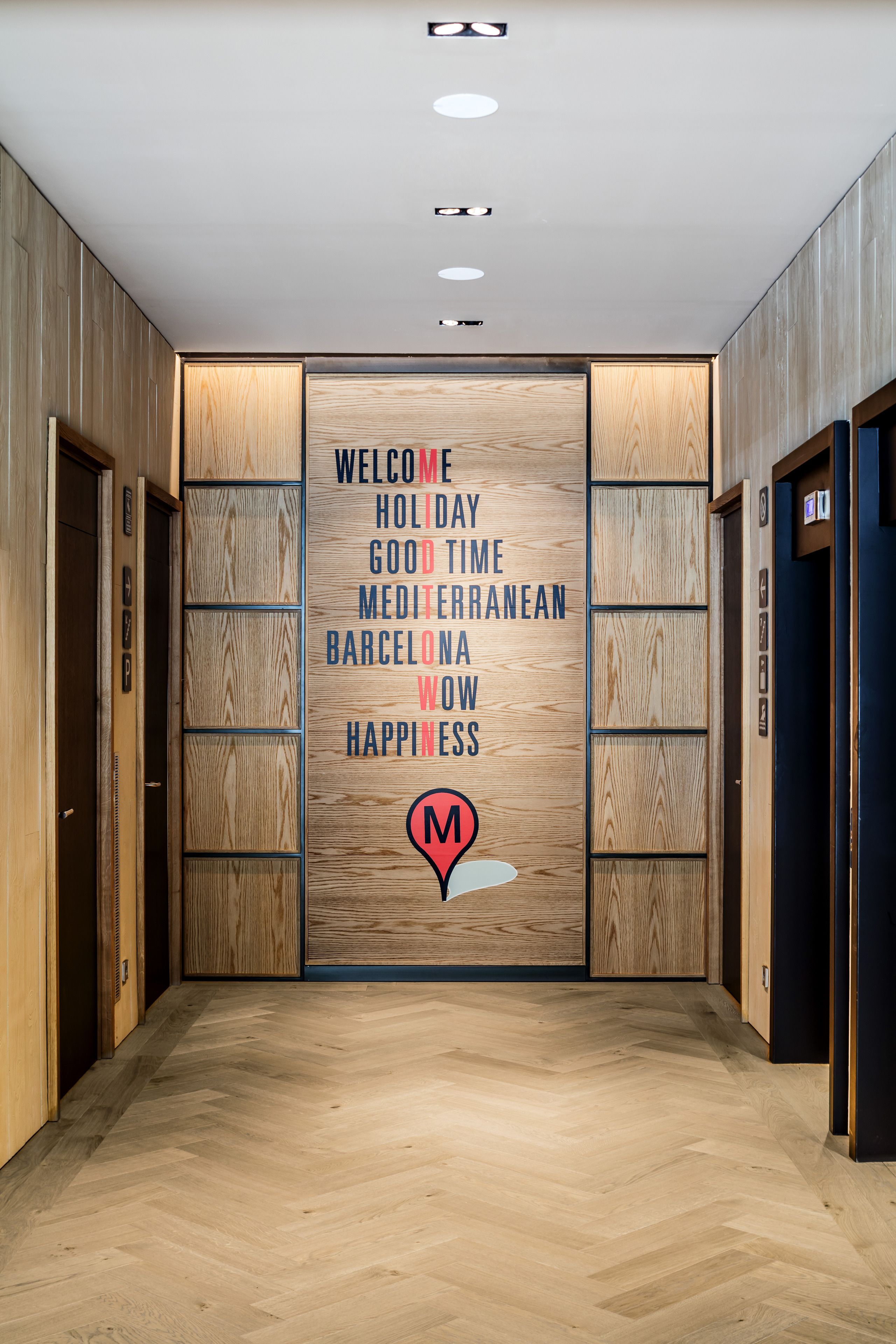 Un pasillo moderno con paneles de madera y un cartel de bienvenida.