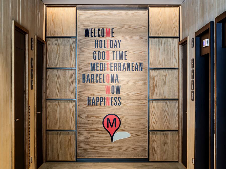 Un pasillo moderno con paneles de madera y un cartel de bienvenida.