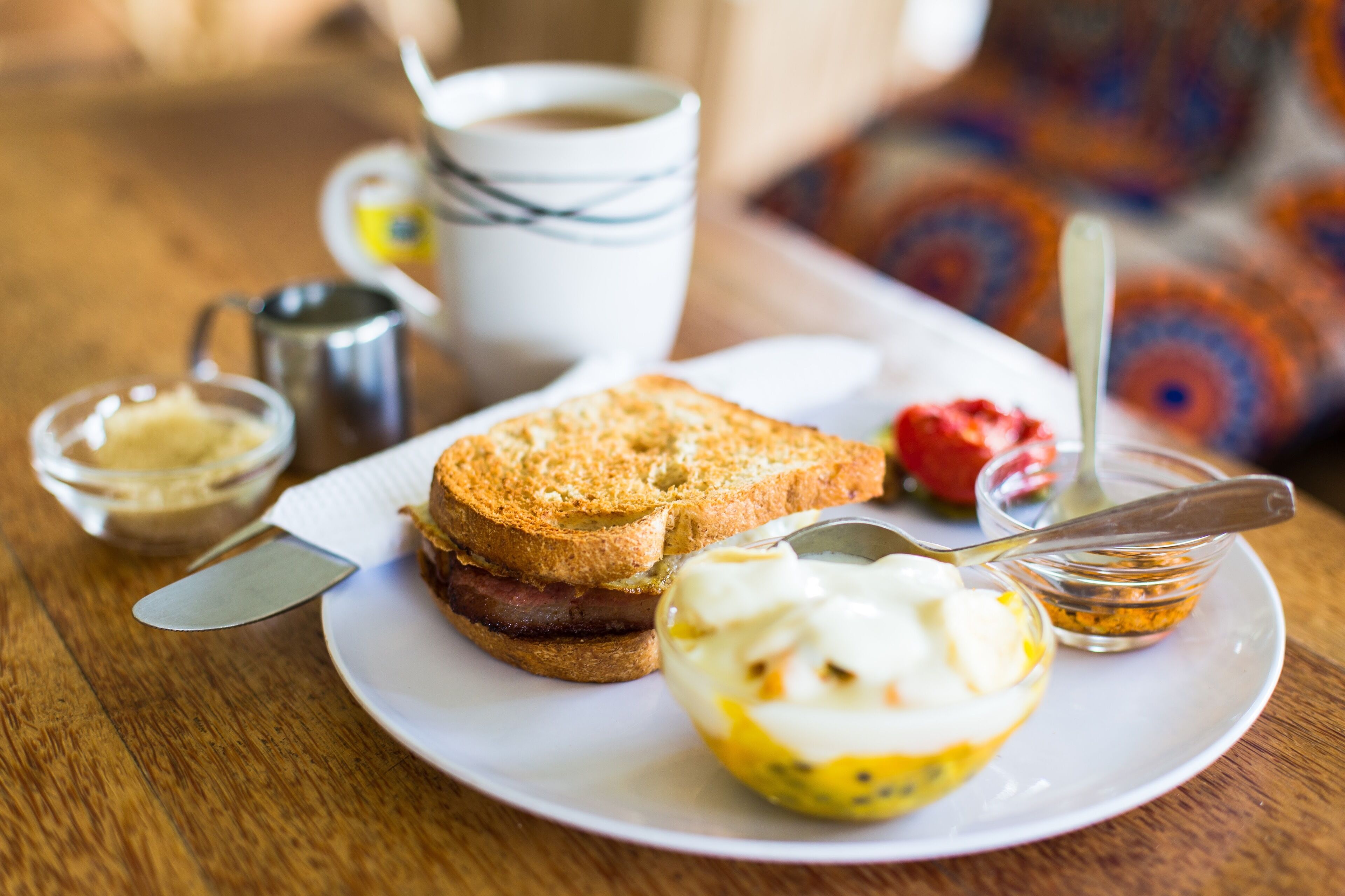 A breakfast plate with toast, bacon, and a poached egg.
