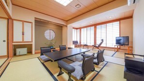 Um quarto em estilo japonês tradicional, com tatames, uma mesa baixa e assentos.
