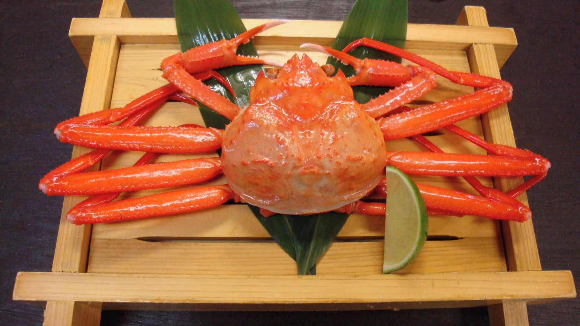 A crab centered on a wooden tray with a lime wedge.