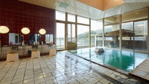 A large indoor swimming pool with a view of a lake, a sauna area, and a large window with a view of the outdoors. - Aga No Megumi Bousenkaku (Gosen)