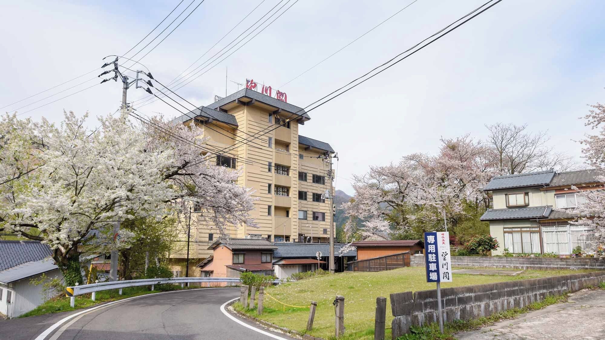 A multi-story building with a flat roof and a sign indicating a parking area.