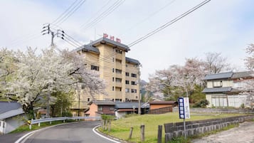 A multi-story building with a flat roof and a sign indicating a parking area.