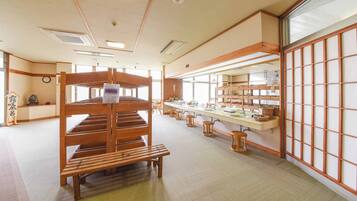 A traditional Japanese-style room with tatami flooring, a wooden shelf unit, and a long counter with stools.