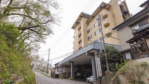 A multi-story building with a traditional architectural style, featuring a covered entrance and a car parked in front. - Aga No Megumi Bousenkaku (Gosen)