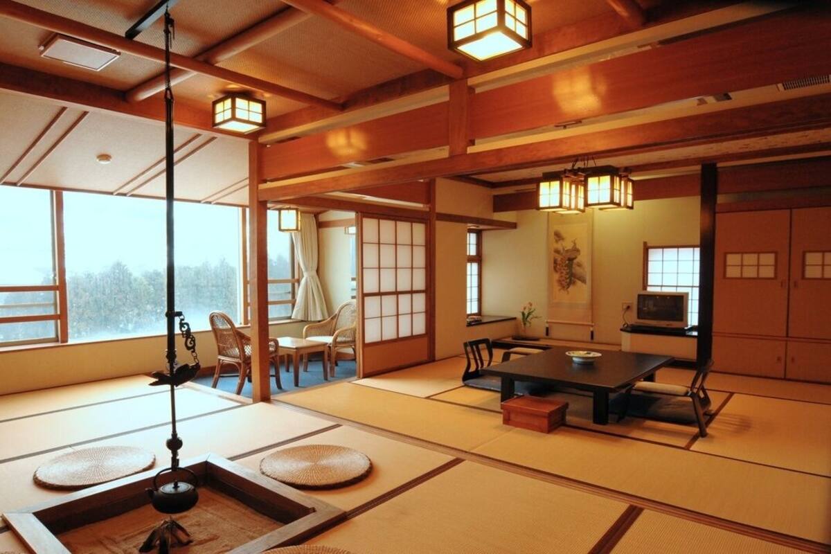 A traditional Japanese room with tatami flooring, low wooden tables, and sliding doors.