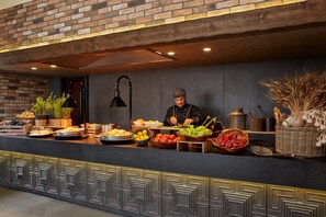 Un chef preparando comida en una barra, con diversos ingredientes y utensilios de cocina.