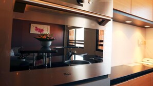 A modern kitchen with a built-in stove, a sink, and a window providing natural light. - Palissandre Hotel & Spa (Antananarivo)