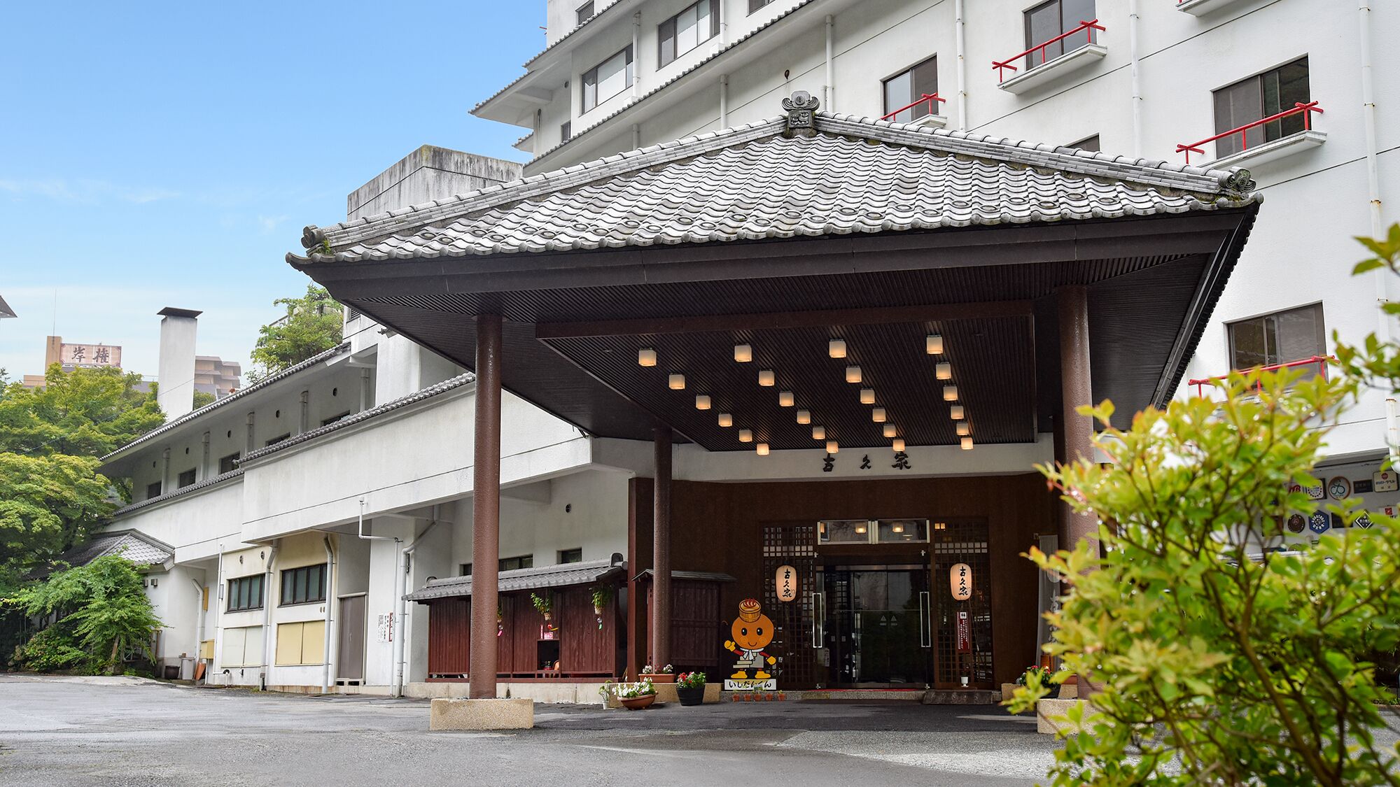 Un edificio japonés tradicional con tejado de tejas, un vestíbulo cubierto y señalización que indica que es un restaurante.