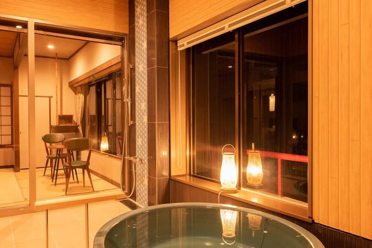 Un intérieur moderne avec une table en verre, un plancher en bois et une vue sur l’extérieur.