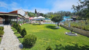 A courtyard with a swimming pool, a covered seating area, and a stone pathway. - Pension Nychterida (Corfu)