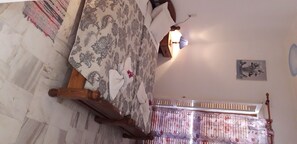 A room with a bed, a nightstand, a lamp, and a painting on the wall. - Pension Nychterida (Corfu)
