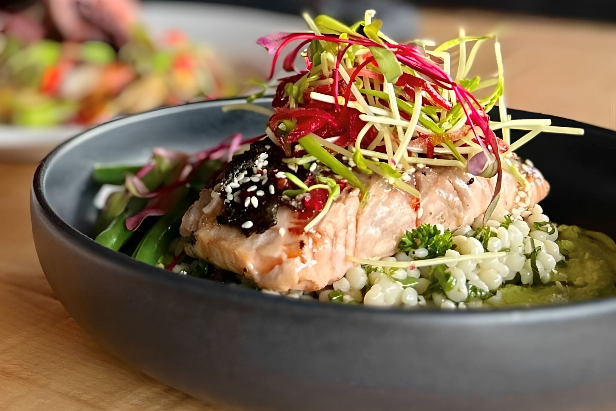Eine Schüssel mit Lachs, Salat und einer dekorativen Garnitur.