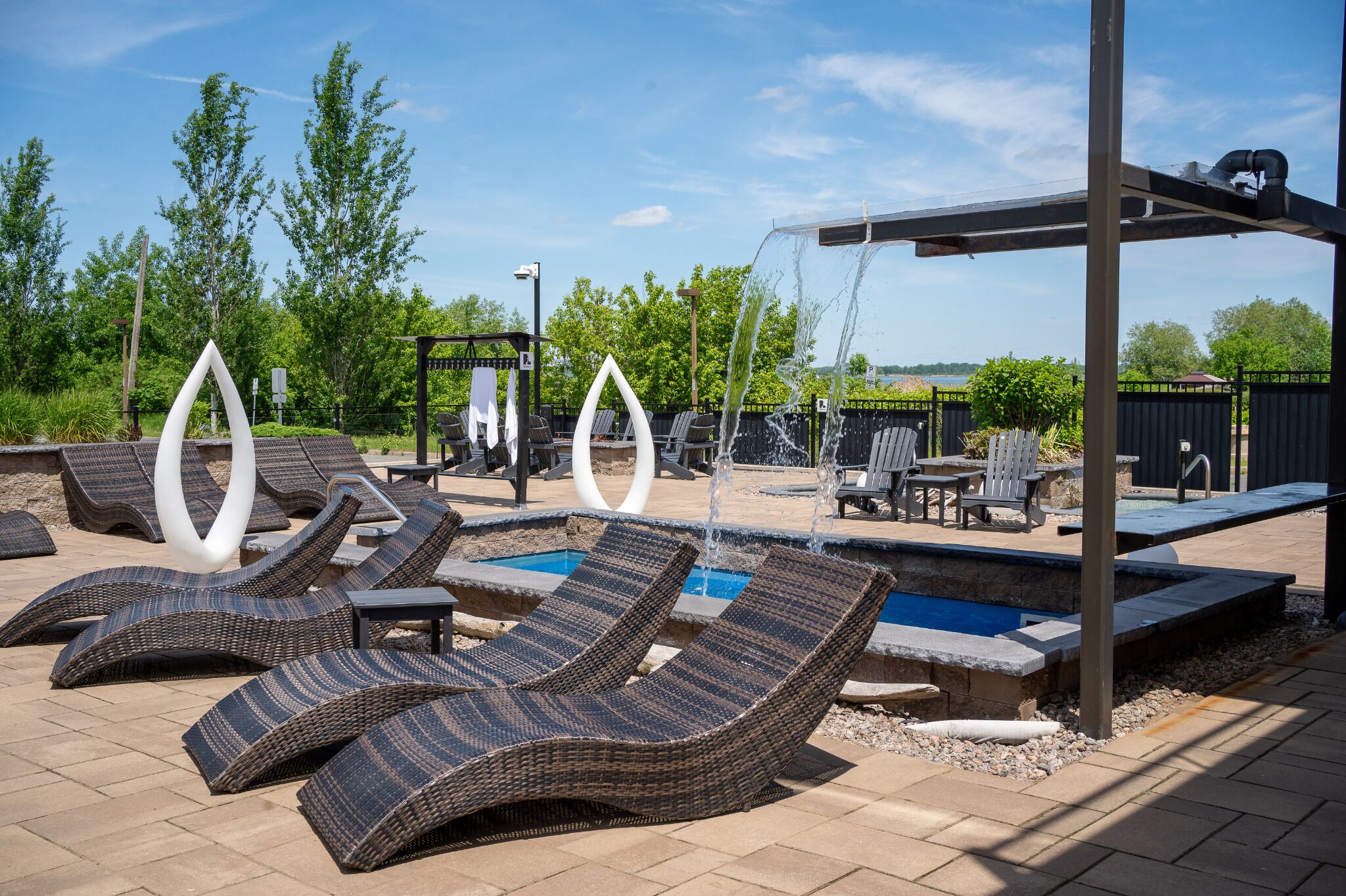 A pool area with lounge chairs, a small pool, and a pergola.
