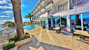 A hotel with a pool, outdoor seating, and a view of the ocean. - Sirena Hotel (Podgora)