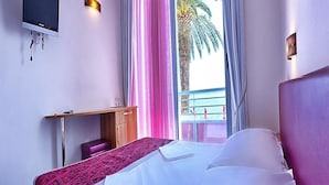 A hotel room with a bed, a desk, a TV, and a window with curtains. - Sirena Hotel (Podgora)