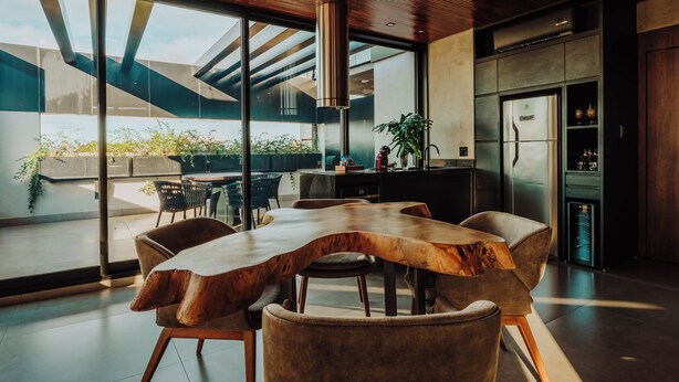 Una cocina moderna con una isla grande, electrodomésticos de acero inoxidable y vistas al exterior.
